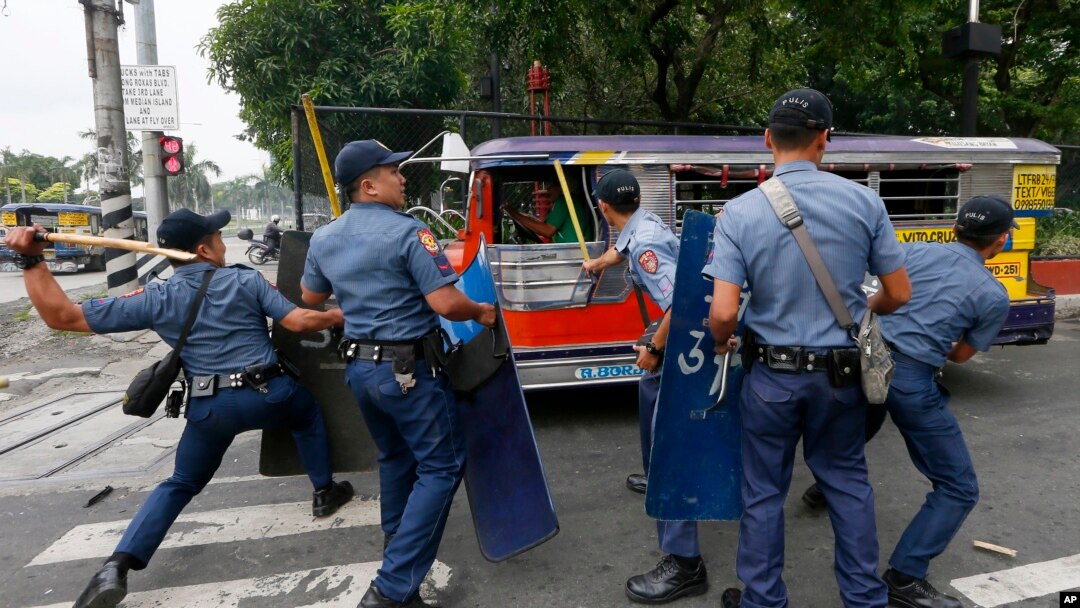 Polisi memukul para demonstran yang kabur saat terjadi kekerasaan saat berunjuk rasa di luar Kedutaan Besar Amerika Serikat di Manila, Filipina (19/10).