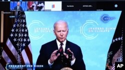 U.S. President Joe Biden is seen on a screen as European Council President Charles Michel attends a virtual Global Climate Summit via video link from the European Council building in Brussels, April 22, 2021.