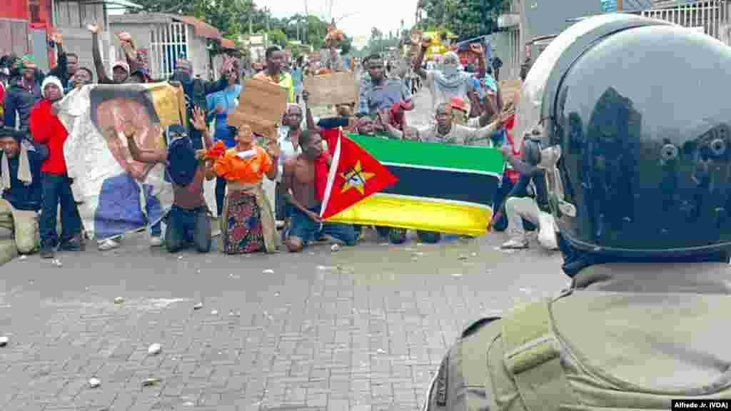 Alguns manifestantes ajoelhados gritam palavras de ordem durante manifestação no bairro Maxaquene, Maputo, Moçambique, 7 de novembro