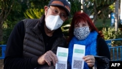 Israelis show their "green pass" (proof of being fully vaccinated against the coronavirus) before entering the Green Pass concert for vaccinated seniors, organized by the municipality of Tel Aviv, on February 24, 2021. (AFP Photo)