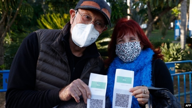 Israelis show their "green pass" (proof of being fully vaccinated against the coronavirus) before entering the Green Pass concert for vaccinated seniors, organized by the municipality of Tel Aviv, on February 24, 2021. (AFP Photo)