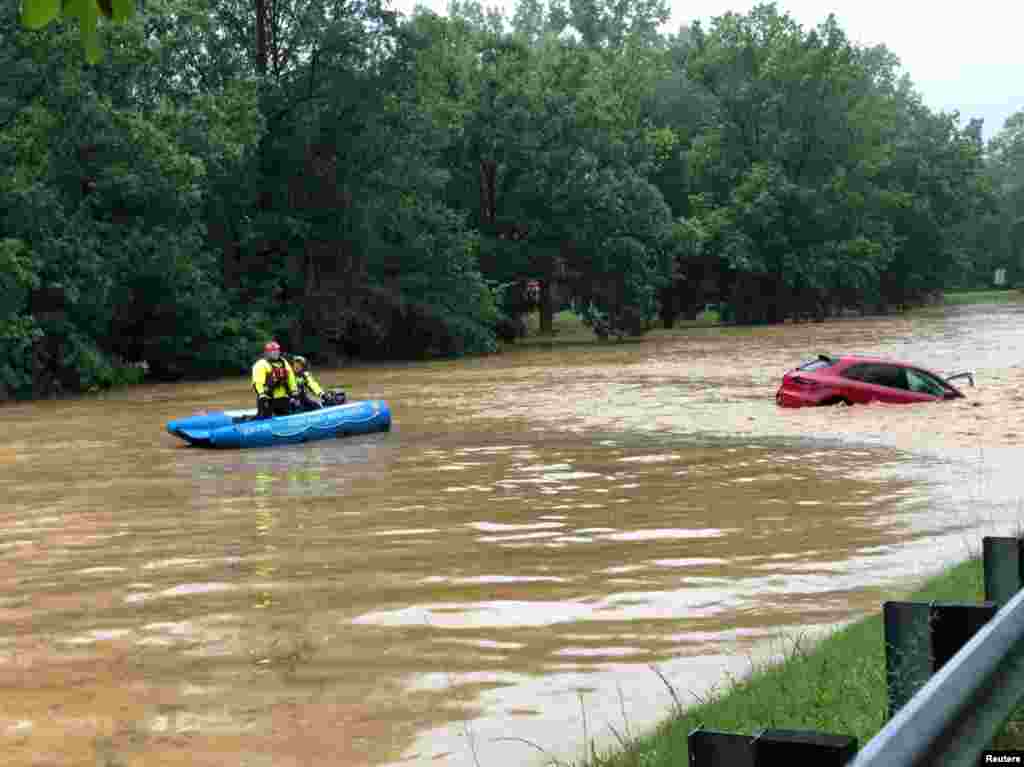 Crew of a water rescue vessel is seen near a car in flood waters on Clara Barton Parkway near Washington, D.C., July 8, 2019 in this picture obtained from social media. (Credit: Twitter/Montgomery County (MD) Fire and Rescue)