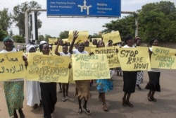 FILE - Women march carrying placards with messages demanding peace and their rights, on the streets of South Sudan's capital, Juba, July 13, 2018.