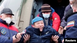 Space flight participant Japanese entrepreneur Yusaku Maezawa disembarks from a helicopter as he arrives at Zhezkazgan airport after returning from the International Space Station on the Soyuz MS-20 space capsule, in Zhezkazgan, Kazakhstan.