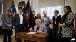 Maine Gov. Janet Mills signs a bill to establish Indigenous Peoples' Day, at the State House in Augusta, Maine, April 26, 2019. 