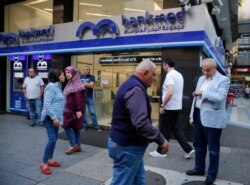 Clients wait outside a bank for its re-opening after a two-week closure, in Beirut, Lebanon, Nov. 1, 2019.