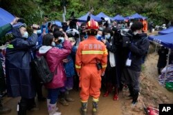 Seorang anggota tim penyelamat memberi pengarahan kepada media di dekat lokasi kecelakaan China Eastern, Kamis, 24 Maret 2022, di Desa Molang, di Provinsi Guangxi, China barat daya. (Foto: AP)