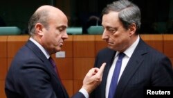 Spain's Economy Minister Luis de Guindos talks to European Central Bank (ECB) President Mario Draghi (R) during a eurozone finance ministers meeting in Brussels, Dec. 17, 2013.