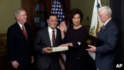 Vice President Mike Pence, right, swears in Transportation Secretary Elaine Chao, second from right, in the Eisenhower Executive Office Building in the White House complex in Washington, Jan. 31, 2017.