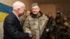 Ukrainian President Petro Poroshenko (R) shakes hands with U.S. Senator John McCain during a meeting with Ukrainian servicemen in Shirokino settlement near Mariupol, Ukraine, Dec. 31, 2016.