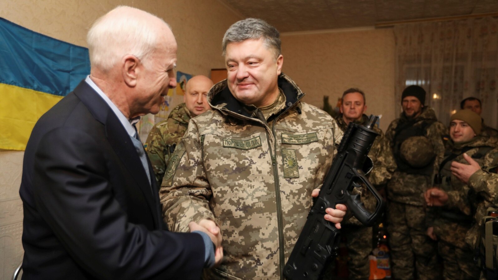Ukrainian President Petro Poroshenko (R) shakes hands with U.S. Senator John McCain during a meeting with Ukrainian servicemen in Shirokino settlement near Mariupol, Ukraine, Dec. 31, 2016.