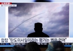 People watch a TV showing an image of North Korea's rocket launch during a news program at the Seoul Railway Station in Seoul, South Korea, Aug. 1, 2019.