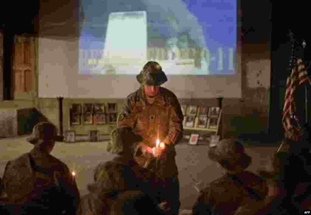 Lt. Col. Daniel Wilson, 47, of San Diego, Calif., commander of the U.S. Army's 2nd Battalion 27th Infantry Regiment of the 25th Infantry Division, 3rd Brigade Combat Team based in Schofield Barracks, Hawaii, lights a candle as an image of the World Trade 