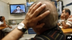 Lebanese watch Hezbollah's leader Hassan Nasrallah as he speaks in a televised address at a cafe in Beirut, Lebanon, Saturday, July 2, 2011.