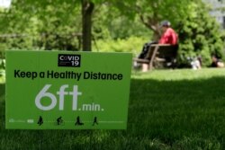 FILE - A sign encouraging social distancing is seen at Independence Park in Evanston, Ill., May 29, 2020.