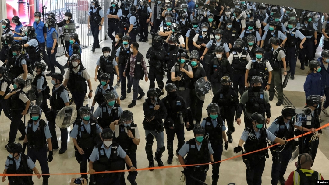 Petugas kepolisian mengenakan masker untuk mencegah penularan Covid-19 membubarkan demo anti-pemerintah di sebuah mal di Hong Kong, China, 28 April 2020. (Foto: Reuters)