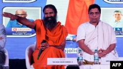 Indian guru Baba Ramdev (L) and Patanjali Ayurveda Managing Director Acharya Balkrishna, are seen during a press conference in New Delhi, India, Jan. 16, 2018.