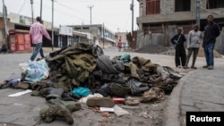 People look at military uniforms and equipment abandoned in the streets of Goma amid conflict between M23 rebels and the Congolese army in Goma, Democratic Republic of the Congo, on Jan. 29, 2025.