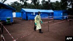 FILE - A health worker walks at an Ebola quarantine unit, June 13, 2017 in Muma, DRC, after a case of Ebola was confirmed in the village.