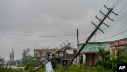 Postes de electricidad caídos y ramas caídas bordean una calle después de que el huracán Ian azotara Pinar del Río, Cuba, el martes 27 de septiembre de 2022. 