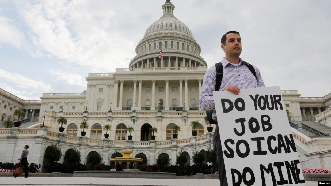 Seorang pegawai federal yang terkena 'furlough' (dirumahkan), memegang kertas bertuliskan pesan kepada para anggota kongres di depan Gedung Capitol, Washington DC, pasca penutupan operasi pemerintah AS (1/10). Penutupan pemerintah AS yang terjadi untuk pertama kalinya dalam 17 tahun terakhir ini, mengakibatkan sekitar sekitar 800 ribu pegawai federal dirumahkan, ditutupnya taman-taman kota dan penundaan berbagai proyek penelitian (REUTERS/Larry Downing).