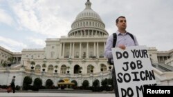 Seorang pegawai federal yang terkena 'furlough' (dirumahkan), memegang kertas bertuliskan pesan kepada para anggota kongres di depan Gedung Capitol, Washington DC, pasca penutupan operasi pemerintah AS (1/10). Penutupan pemerintah AS yang terjadi untuk pertama kalinya dalam 17 tahun terakhir ini, mengakibatkan sekitar sekitar 800 ribu pegawai federal dirumahkan, ditutupnya taman-taman kota dan penundaan berbagai proyek penelitian (REUTERS/Larry Downing).