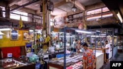 FILE - People visit a Buddhist amulet market in Bangkok on June 2, 2020.