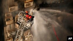 Firefighters work to douse a fire in a multi-storied office building in Dhaka, Bangladesh, March 28, 2019. 