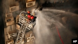 Firefighters work to douse a fire in a multi-storied office building in Dhaka, Bangladesh, March 28, 2019. 