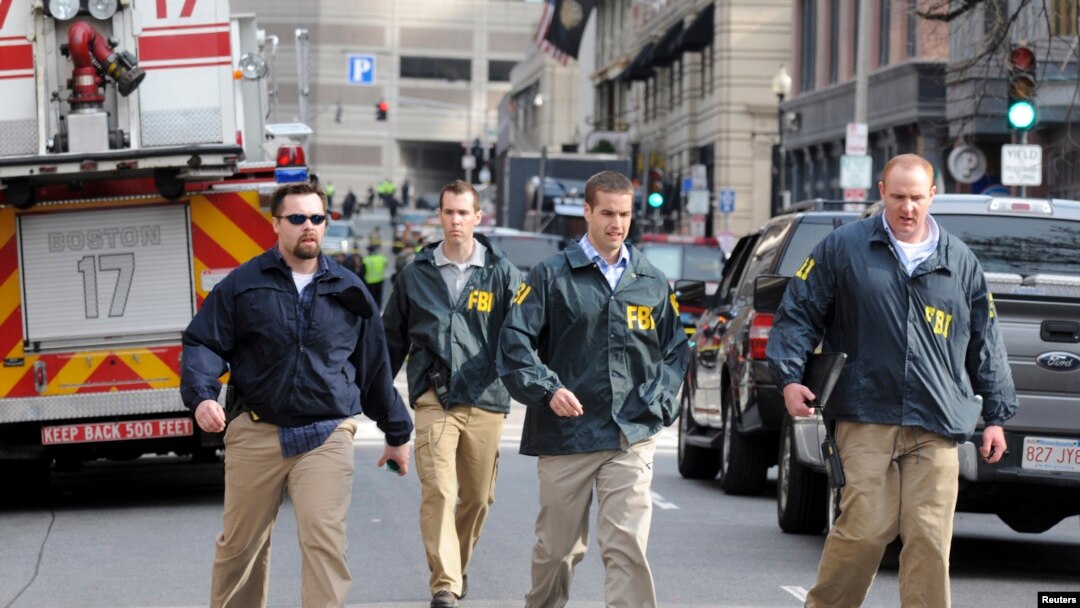 Para petugas Biro Penyidikan Federal (FBI) segera menyelidiki situasi di lokasi kejadian ledakan bom, dekat garis finish lomba marathon Boston, Massachusetts (15/4). 