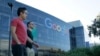 FILE - Two men walk past a building on the Google campus in Mountain View, California. 