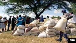 A man carries a full bag of donated maize grain, March 13, 2019, in the Mutoko rural area of Zimbabwe. Eastern Zimbabwe receives help to fight drought induced hunger, as a total of 32,000 villagers affected by drought in the Mutoko area. They received…