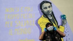 Građanin Rima ispred murala sa Gretom Tunberg i njenom porukom: "Nikada niste suviše mladi da spasite svet", 30. marta 2020, za vreme pandemije Kovida-19.