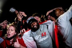 Los fanáticos de los Tampa Bay Buccaneers celebran su victoria sobre los Kansas City Chiefs durante el Super Bowl LV en un estacionamiento cerca del Estadio Raymond James en Tampa, Florida, el 7 de febrero de 2021.