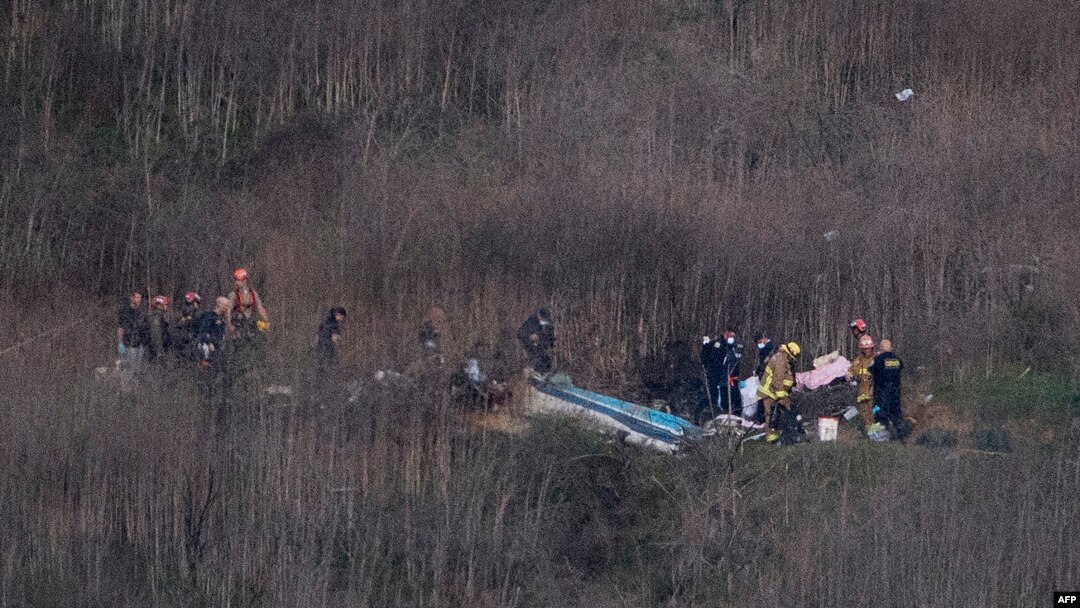 Petugas dari Dinas Pemadam Kebakaran Los Angeles mengevakuasi sisa-sisa jasad dari lokasi jatuhnya helikopter di Calabasas, California, 26 Januari 2020. 