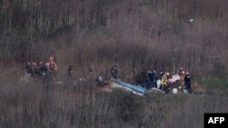 Petugas dari Dinas Pemadam Kebakaran Los Angeles mengevakuasi sisa-sisa jasad dari lokasi jatuhnya helikopter di Calabasas, California, 26 Januari 2020. 