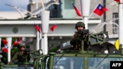 Vehículos militares patrullan frente al aeropuerto Songshan en Taipei el 14 de octubre de 2024.