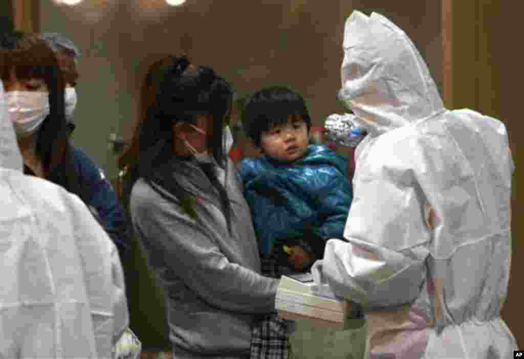 A child is screened for radiation exposure at a testing center in Koriyama city, Fukushima Prefecture, Japan, after a nuclear power plant on the coast of the prefecture was damaged by Friday's earthquake, March 15, 2011