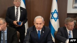 FILE - Israeli Prime Minister Benjamin Netanyahu eats an apple slice to mark the upcoming Jewish New Year holiday during the weekly Cabinet meeting in Jerusalem on Sept 10, 2023.