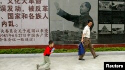 Visitors walk past a portrait of the late Chinese leader Mao Zedong at the Cultural Revolution Museum in Shantou in China's southern Guangdong province May 15, 2006.