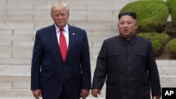 Presiden AS Donald Trump dan pemimpin Korea Utara Kim Jong Un dalam pertemuan terakhir mereka di Panmunjom, 30 Juni 2019 lalu (foto: dok). 