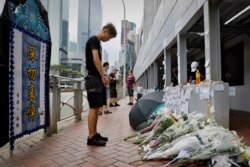 A man pays respect on the site where a man fell to his death a day earlier after hanging a protest banner against the extradition bill on the scaffolding of a shopping mall in Hong Kong, June 16, 2019.