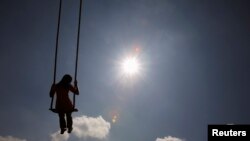 FILE - A girl plays on a swing during the Hindu festival of Dasain in Kathmandu, Nepal, Sept. 29, 2011. 