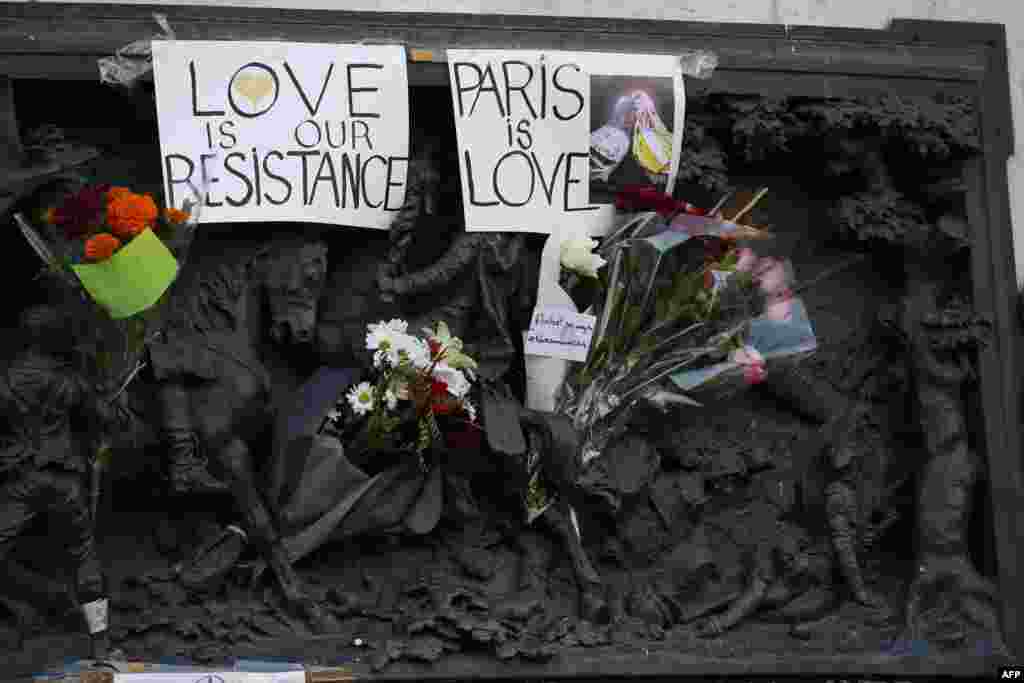 Placards reading 'Love is our resistance' and 'Paris is love' are pictured at the Monument a la Republique, at the Place de la Republique in Paris, on Nov. 15, 2015, two days after a series of deadly attacks. 