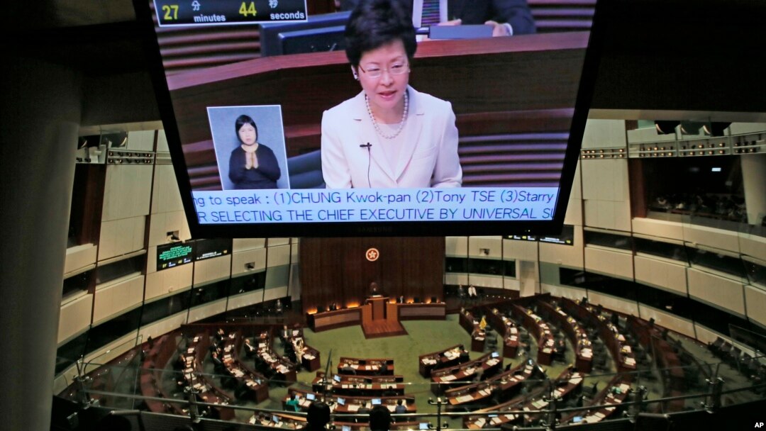 Chief Secretary Carrie Lam is seen on a TV screen as she unveils the Beijing-backed election reform package’s details at the legislative chamber in Hong Kong, April 22, 2015. 