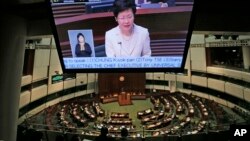 香港政務司司長林鄭月娥在立法會宣讀政改方案聲明,她的影像出現在大型投影機上