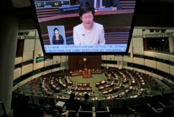 Chief Secretary Carrie Lam is seen on a TV screen as she unveils the Beijing-backed election reform package’s details at the legislative chamber in Hong Kong, April 22, 2015.