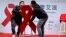 Men move a red ribbon display at an event to promote awareness of HIV testing ahead of the December 1 World AIDS Day, in Beijing, China, Nov. 27, 2014.
