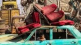 پسر بچه در گورستان خودروهای فرسوده در تهران بازی میکند.