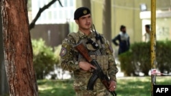 An Afghan policeman stands guard in the courtyard of the police headquarters in Kabul, Oct. 12, 2020.